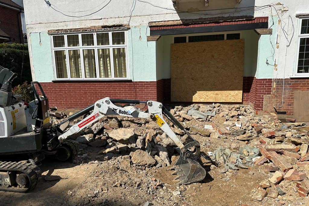 Mini excavator breaking out the old conservatory base at the Harpenden house