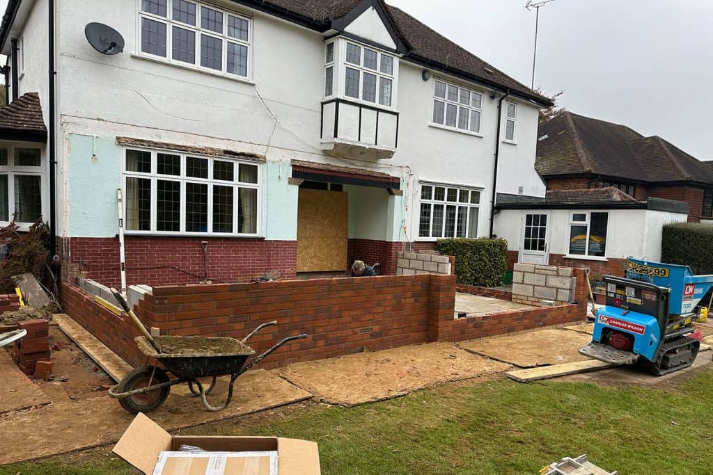 New brick cavity walls rising beside the Harpenden house