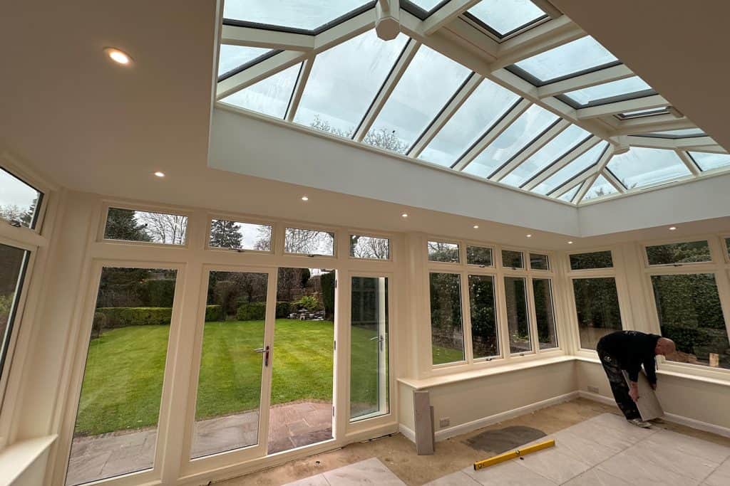 Decorated orangery interior with floor tiling underway beneath the roof lantern