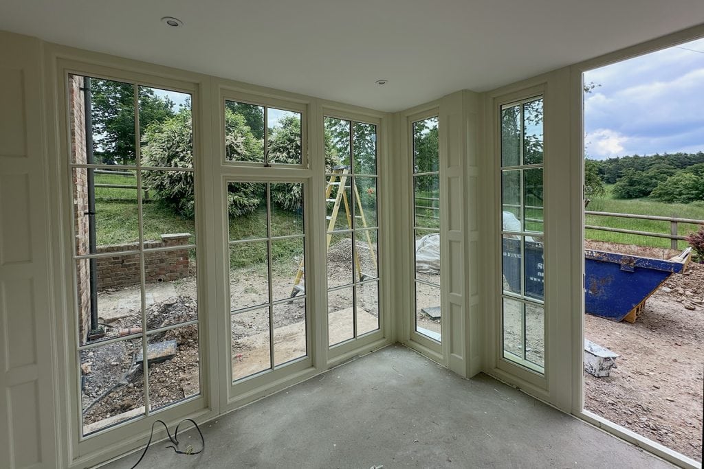 Garden room interior with a painted ceiling, Georgian-style glazing and screeded floor