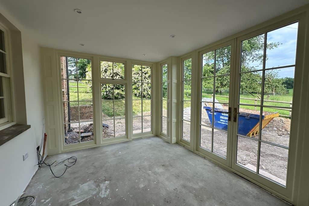 Garden room interior nearing completion with glazed doors overlooking the grounds