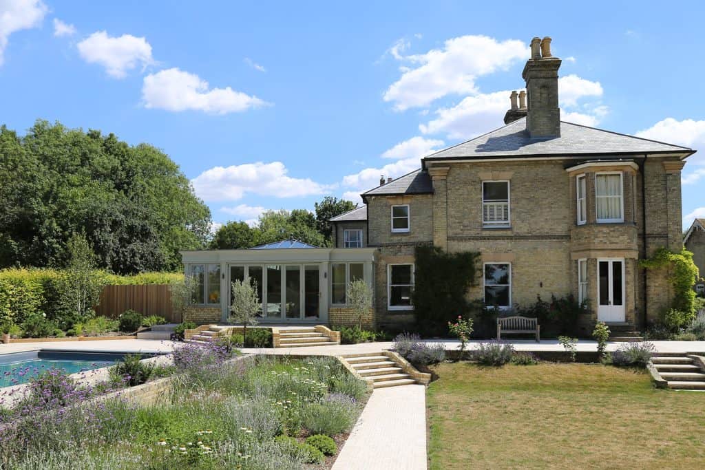 Completed orangery, Victorian villa and landscaped garden under a blue sky