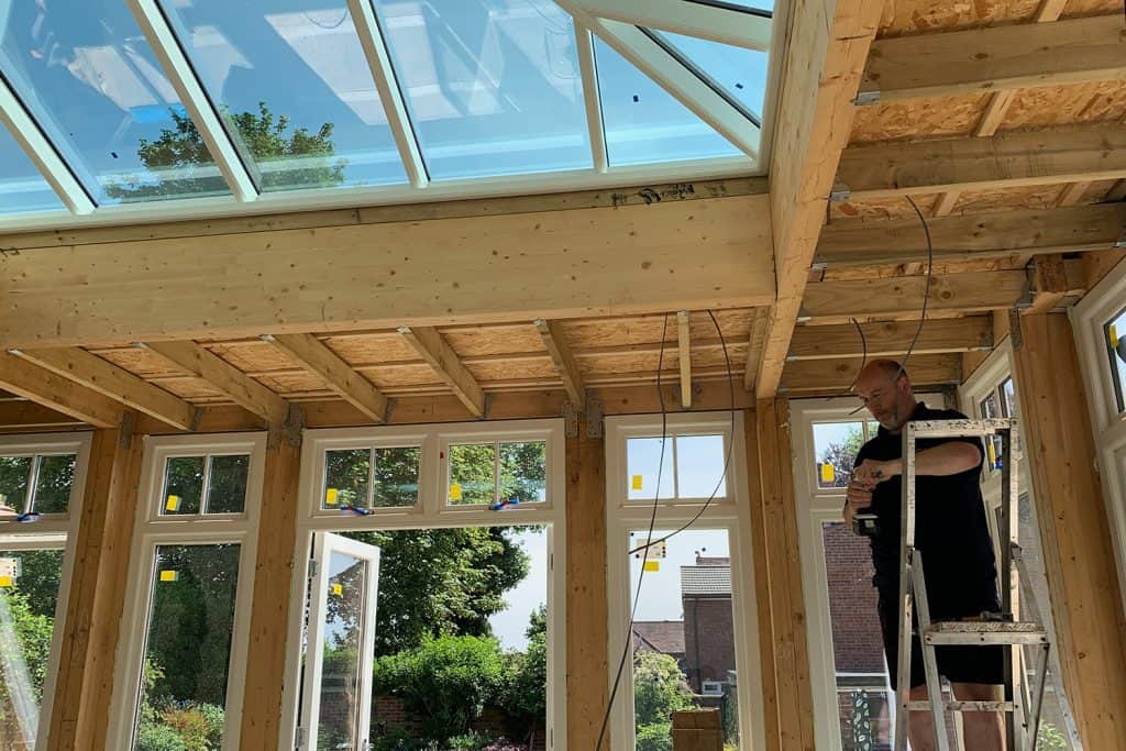 Electrician carrying out first-fix wiring beneath the roof lantern