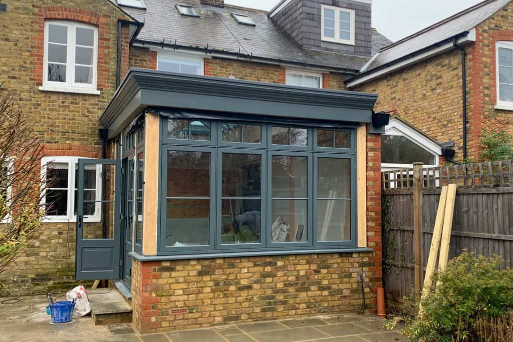 Dark grey windows fitted to the orangery before the exterior post covers were installed