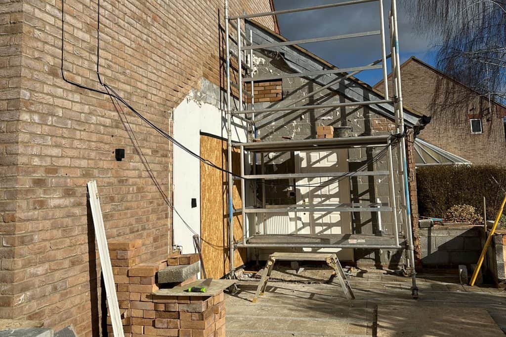 Structural frame and scaffolding being erected at the rear of the house