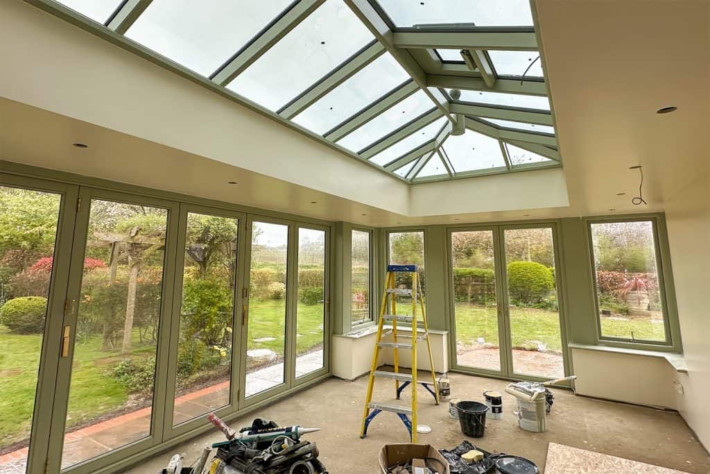 Orangery interior during finishing, with glazed roof lantern and garden doors