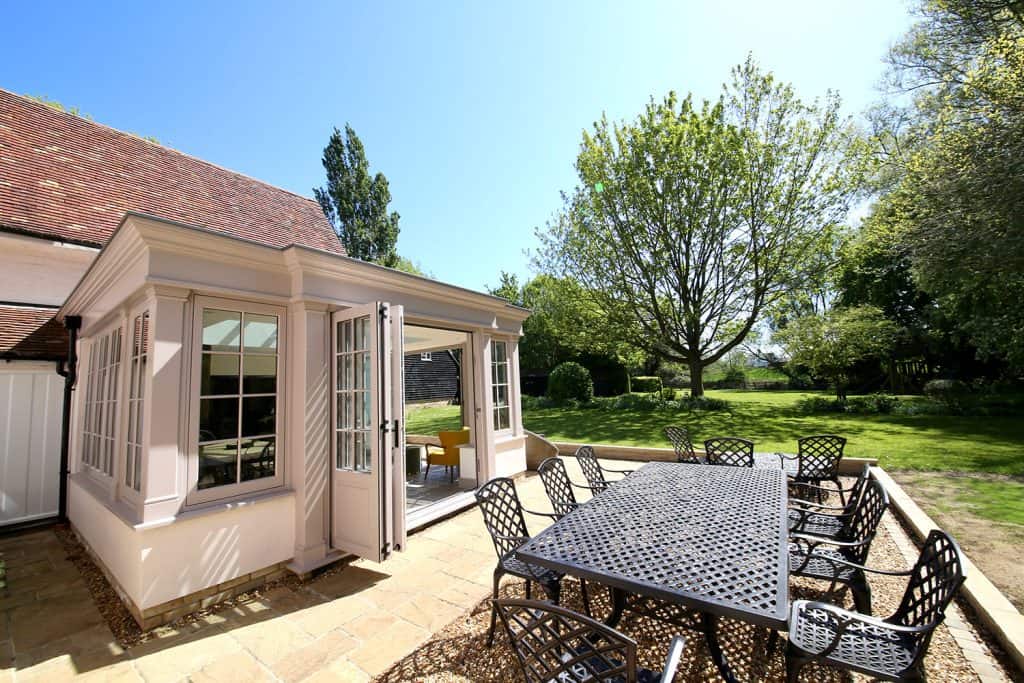 Finished orangery with open bifold doors and patio overlooking the garden