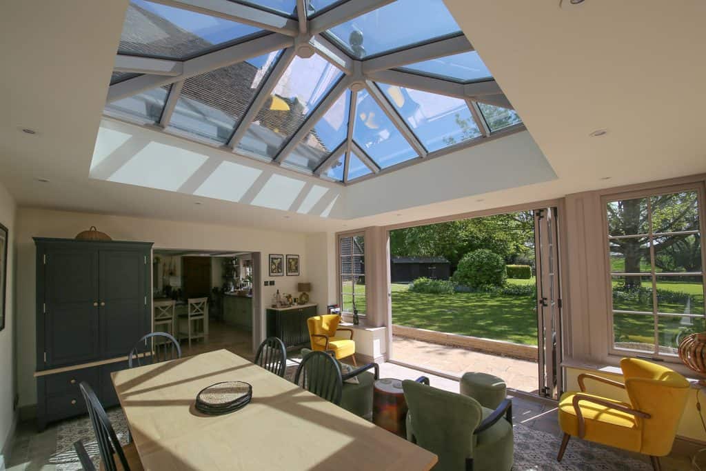 Finished orangery dining area beneath a glazed roof lantern