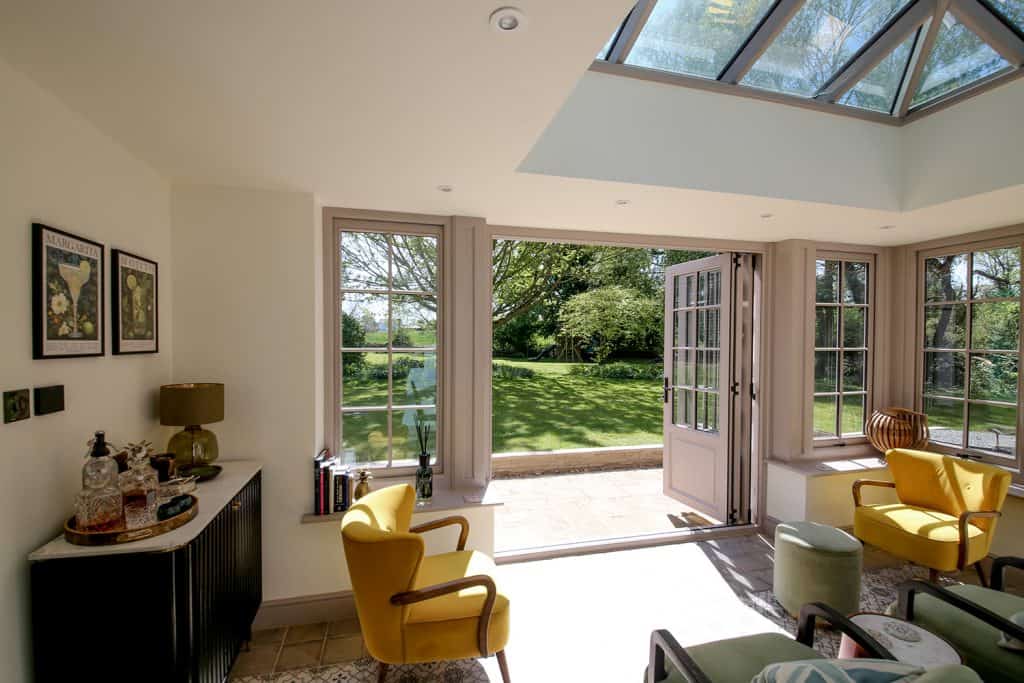 Orangery seating area with bifold doors open towards the garden